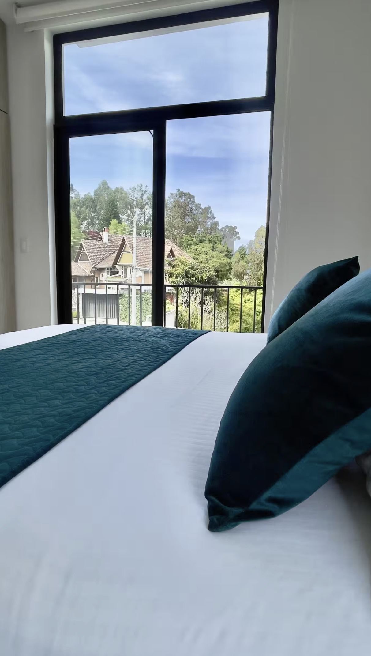 Bedroom, teal cushions and balcony